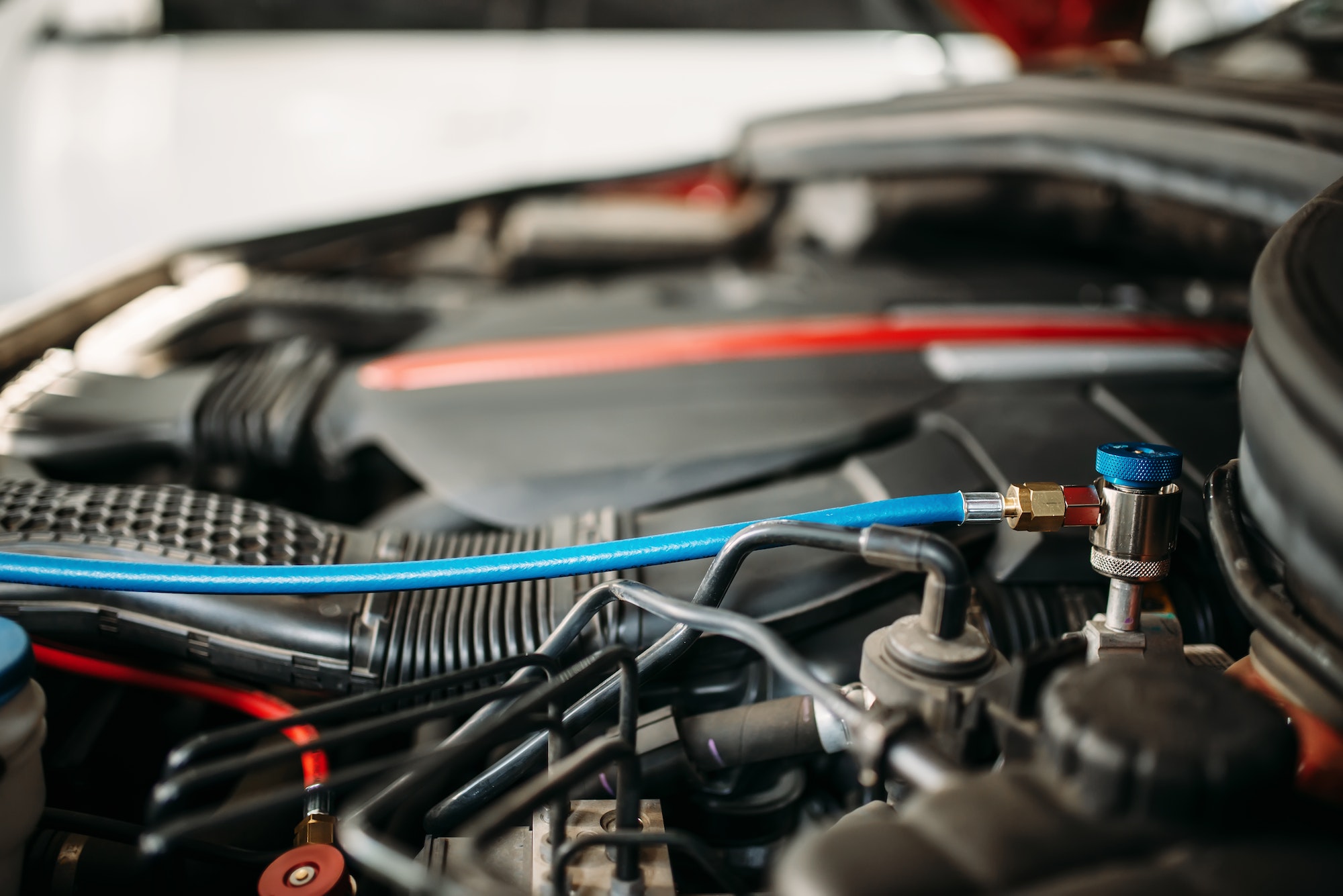 Air conditioning diagnostic equipment connected to a vehicle engine